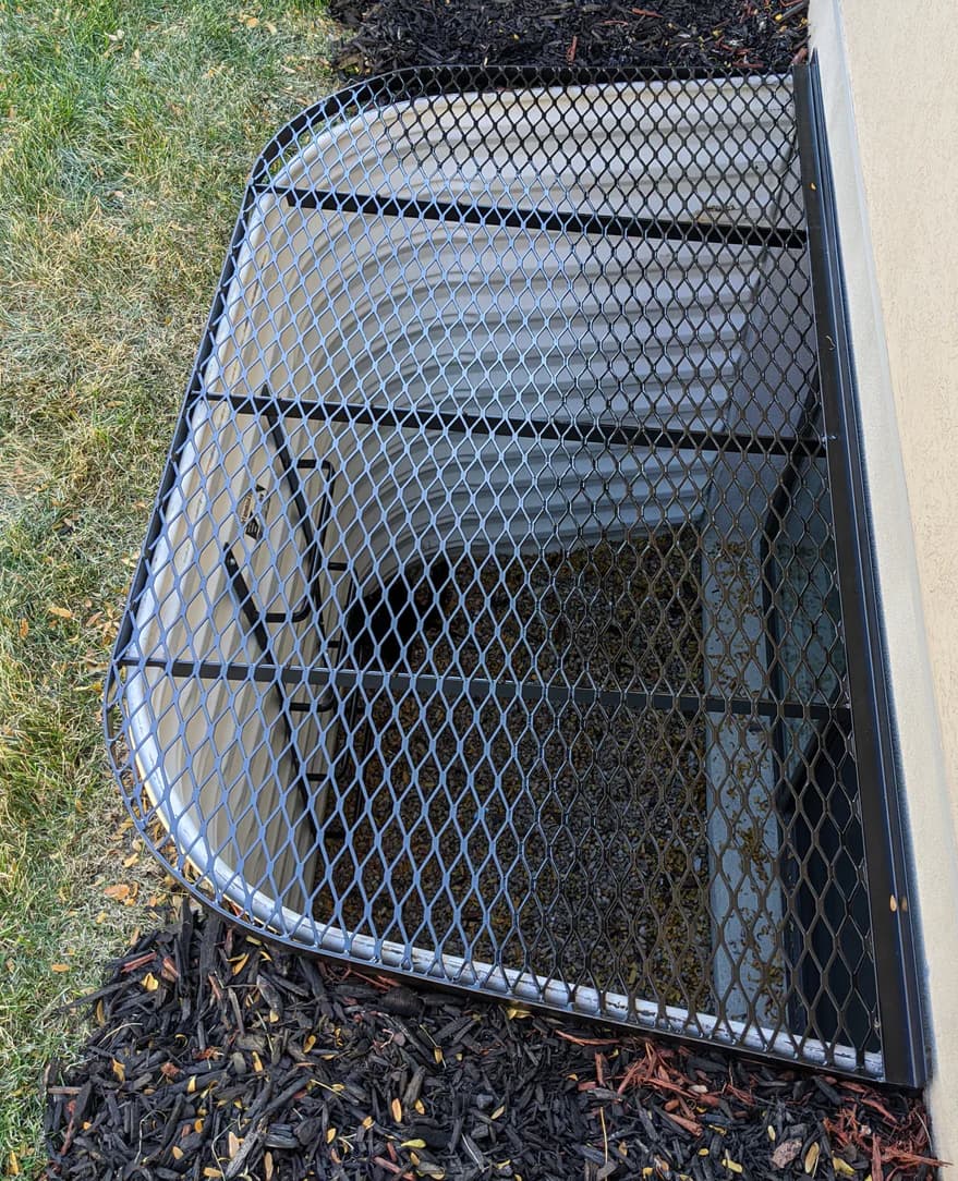 Window well fitted with a metal grate cover